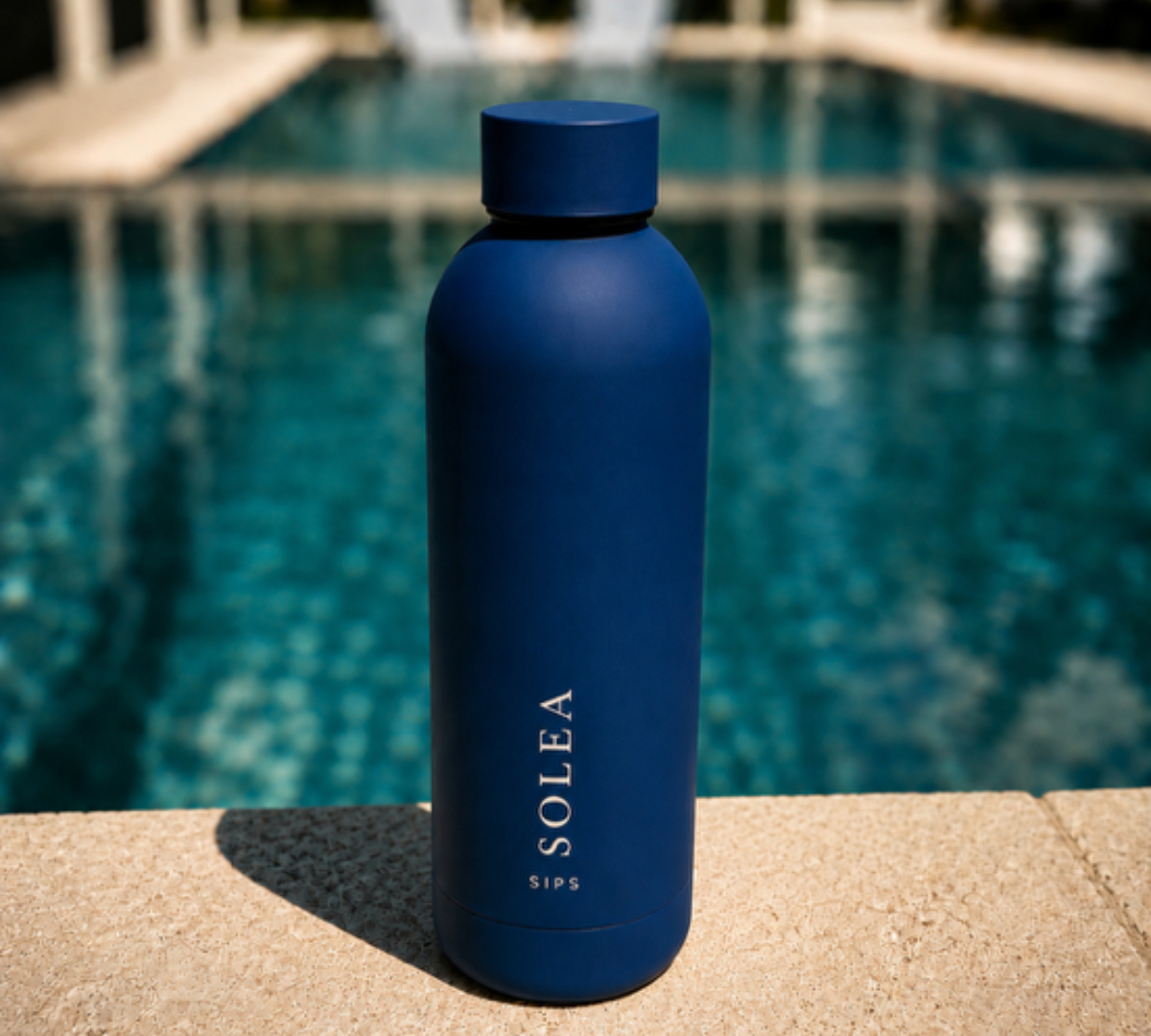 Blue water bottle with 'Solea' branding by a pool